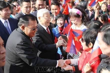 Le secrétaire général du Parti Nguyên Phu Trong et le secrétaire général du Parti et président du Laos Bounnhang Vorachith rencontrent des habitants , à Hanoi, le 22 juillet 2024. Photo : VNA.