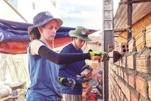 Deux jeunes Américains posent des briques dans la province de Quang Ngai, au Centre. Photo : CVN.