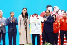 Le Premier ministre Pham Minh Chinh offre le maillot de l’équipe féminine de football du Vietnam à la Première ministre néo-zélandaise, Jacinda Ardern. Photo : VFF.