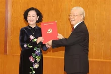 Le Secrétaire général du Parti, Nguyên Phu Trong, remet la décision du Bureau Politique d'affecter Truong Thi Mai, membre du Bureau politique, secrétaire du Comité central du Parti et présidente de la Commission centrale d'Organisation du Parti, au poste de Permanente du Secrétariat du Comité central du Parti du XIIIe mandat. Photo : VNA.