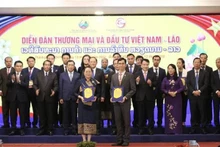Cérémonie d'échange des accords de coopération entre les entreprises vietnamiennes et lao lors du forum. Photo : VNA.