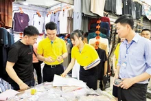 Des employés de banque guident les commerçants au marché de Mong Cai sur les paiements dématérialisés.