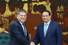 Le Premier ministre Pham Minh Chinh (à droite) serre la main du président-directeur général d’AstraZeneca Vietnam, Nitin Kapoor, à Hanoi, le 5 mars. Photo : VNA. 