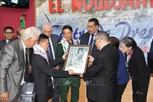 L'ambassadeur du Vietnam en Algérie, Trân Quôc Khanh, remet au directeur général du quotidien El Moudjahid, Brahim Takheroubt, une photo du général Vo Nguyên Giap lors de sa visite en Algérie en 1976. Photo : VNA.