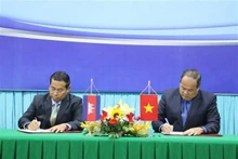 Le président du Comité populaire d'An Giang, Nguyen Thanh Binh (droite) et le gouverneur de Takeo, Ouch Phea ont signé un accord de coopération entre An Giang et Takeo pour la prochaine période. Photo : VNA