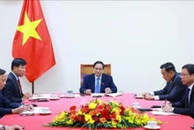 Le Premier ministre Pham Minh Chinh (au centre) s’entretient par téléphone avec le secrétaire général du PAP et Premier ministre singapourien Lawrence Wong. Photo : VNA.