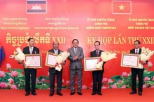 Le général de corps d'armée Vo Minh Luong remet l'Ordre de l'Amitié du Président de la République socialiste du Vietnam à quatre individus du Cambodge. Photo: VNA