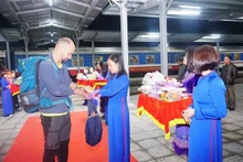 Des cadeaux aux premiers touristes étrangers à Lào Cai. Photo : VNA.