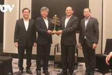 Les dirigeants du groupe VRG offrent un cadeau souvenir à Sonexay Siphandone, Premier ministre du Laos. Photo : VOV.