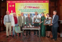 Des représentants de la famille de Pham Van Công remet deux photos immortalisant la visite du Président Hô Chi Minh à leur domicile, lors du réveillon du Têt 1963. Photo : VNA.
