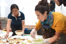 Une touriste étrangère à Sa Pa participe à la préparation de repas de charité à envoyer aux zones inondées. Photo : VOV.