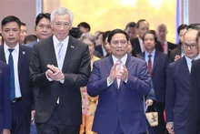 Le Premier ministre vietnamien Pham Minh Chinh (à droite) et son homologue singapourien Lee Hsien Loong participent à la conférence. Photo : VNA.