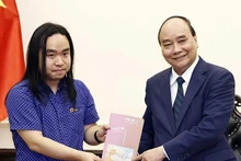 Le Président Nguyên Xuân Phuc (à droite) et le jeune talent littéraire Nguyên Binh. Photo : VNA.