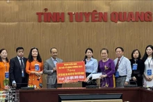 La délégation des Vietnamiens d'outre-mer présente des dons, contribuant au programme d'élimination de l'habitat précaire dans la province de Tuyên Quang. Photo : VNA.