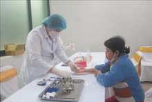 Une patiente se fait consulter par une médecin dans un établissement de santé à Hanoï. Photo : VNA.