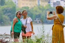 Des touristes visitent le lac Hoàn Kiêm, au coeur de la capitale Hanoi. Photo : VNA.