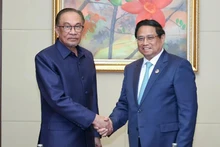 Le Premier ministre Pham Minh Chinh (à droite) et son homologue malaisien Anwar Ibrahim, à Vientiane, le 10 octobre. Photo: VNA