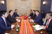 Le Président de l’Assemblée nationale du Vietnam Vuong Dinh Huê (à gauche, centre) et son homologue lao Saysomphone Phomvihane, à Jakarta, le 7 août. Photo : VNA