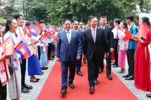 Les Premiers ministres Pham Minh Chinh (à gauche) et Samdech Moha Bovor Thipadei Hun Manet visitent l’Université du commerce extérieur à Hanoï. Photo : VNA.