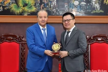 Le rédacteur en chef Lê Quôc Minh (à droite) offre à l'ambassadeur Abdelhamid Boubazine le logo du Journal Nhan Dan. Photo : NDEL.