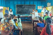 La mission du ministère vietnamien des Affaires étrangères visite une classe d'enfants d'origine vietnamienne dans le village flottant de Kbal Tao, commune de Koh Chiveang, district d'Ek Phnom, province de Battambang, Cambodge. Photo : VNA.