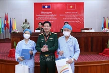 Le général de brigade Nguyên Xuân Kiên, directeur de l’Académie de médecine militaire du Vietnam, offre des cadeaux aux deux patients lao des deux greffes de rein. Photo : VNA.