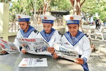 Des soldats dans l'archipel de Truong Sa du Vietnam lisent le Journal Nhân Dân. Photo : NDEL.