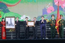 Le Président de l'AN, Vuong Dinh Huê, remet l'Ordre de l'Indépendance de deuxième classe aux autorités et à la population de Vinh. Photo: VNA