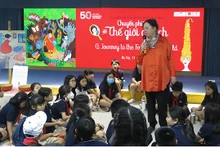 L’artiste danoise Tove K. Lange échange avec des enfants vietnamiens. Photo : Linh Vi/NDEL.