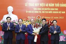 Des dirigeants félicitent le Président Nguyên Xuân Phuc (au milieu). Photo : VNA.