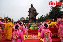 Des habitants offrent de l'encens devant la statue du roi Quang Trung. Photo : VNA.