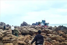 Le personnel du poste de garde-frontière de Quan Lan évalue les dégâts du navire chinois. Photo : VNA.