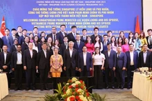 Le Premier ministre vietnamien Pham Minh Chinh, son homologue Lee Hsien Loong et leurs épouses et les jeunes exemplaires des deux pays. Photo : VNA.