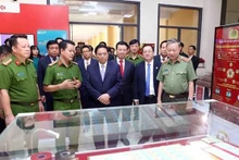 Le Premier ministre Pham Minh Chinh examinant des produits transformation numérique en exposition en marge de la conférence. Photo : VNA.