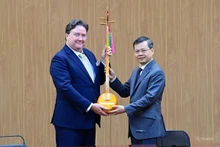 Le président du Comité populaire provincial, Nguyen Van Son, offre à l'ambassadeur des États-Unis à Hanoi un dan tinh (luth à la main), un instrument de musique traditionnel unique de l’ethnie Tay de Tuyen Quang. Photo : daidoanket.vn