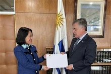L'ambassadrice vietnamienne en Argentine et en Uruguay, Ngo Minh Nguyet (à gauche) présente sa copie des lettres de créance au ministre uruguayen des Affaires étrangères, Omar Paganini. Photo : baoquocte.vn