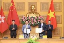 Le vice-Premier ministre Trân Luu Quang (à droite) et le chef de l'exécutif de la région administrative spéciale de Hong Kong, Lee Ka-chiu (à gauche) assistent à l'échange du protocole d'accord entre Vietnam Airlines et l'aéroport international de Hong Kong (HKIA). Photo : VNA.