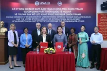 Lors de la cérémonie de signature du protocole d’accord de coopération dans le règlement des conséquences de guerre entre l'USAID et le Musée des vestiges de guerre. Photo : VNA.