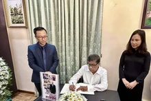 Le secrétaire général du Parti communiste du Sri Lanka G.Weerasinghe écrit dans le registre de condoléances à la mémoire du secrétaire général Nguyên Phu Trong. Photo : VNA.