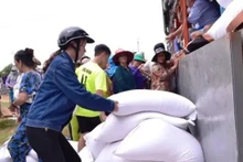 Les gens reçoivent du riz alloué par l'État. Photo : thanhnien.vn