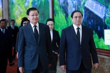 Le Premier ministre Pham Minh Chinh (à droite) et le secrétaire général du Parti populaire révolutionnaire lao (PPRL) et président lao Thongloun Sisoulith, à Hanoi, le 26 juillet. Photo : VNA.