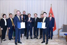 Le Premier ministre Pham Minh Chinh (centre) assiste à la remise du protocole d'accord sur la recherche d'investissement dans le projet de complexe sportif et de centre commercial à Dong Anh entre T&T du Vietnam et JTA International Holding. Photo : VNA. 