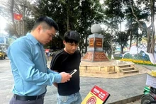 Un touriste s'enregistre au kilomètre 0, ville de Hà Giang. Photo : NDEL.
