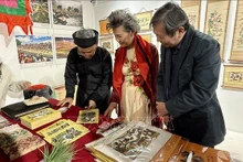 L’artisan Nguyên Dang Tâm présente au public les matériaux et les moules en bois, tout en expliquant la technique d’impression des estampes de Dông Hô. Photo : VNA