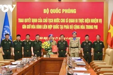 Le général Hoàng Xuân Chiên, vice-ministre de la Défense remet au major Su Tân Phi Long la décision présidentielle officialisant son déploiement à la mission de maintien de la paix en Afrique centrale. Photo : VOV.