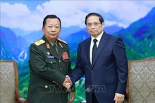 Le Premier ministre Pham Minh Chinh (droite) a reçu le 25 juillet à Hanoï le général Chansamone Chanyalath, vice-Premier ministre et ministre de la Défense du Laos, venu rendre hommage au Secrétaire général Vietnam Nguyên Phu Trong. Photo : VNA.