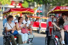 Des touristes étrangers prennent un cyclo-pousse pour découvrir le Vieux quartier de Hanoi. Photo : VNA.