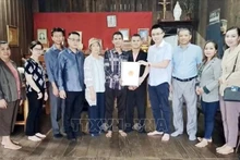 Des représentants du Consulat général du Vietnam dans la ville de Pakse, dans la province lao de Champassak, en collaboration avec l'Association des Vietnamiens de Champassak remettent des cadeaux à 23 familles des personnes méritantes. Photo : VNA