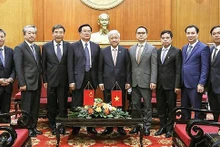 Do Van Chien (5e, droite) et Wang Guosheng (6e, droite) lors de la réception. Photo: VNA