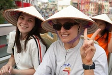 Deux touristes profite du circuit en bus à deux étages proposé par la ville de Hanoï. Photo : nhandan.vn